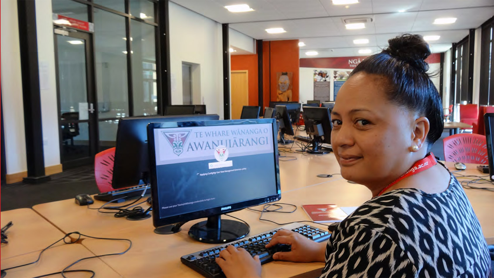 student sitting at laptop at Awanuiārangi library